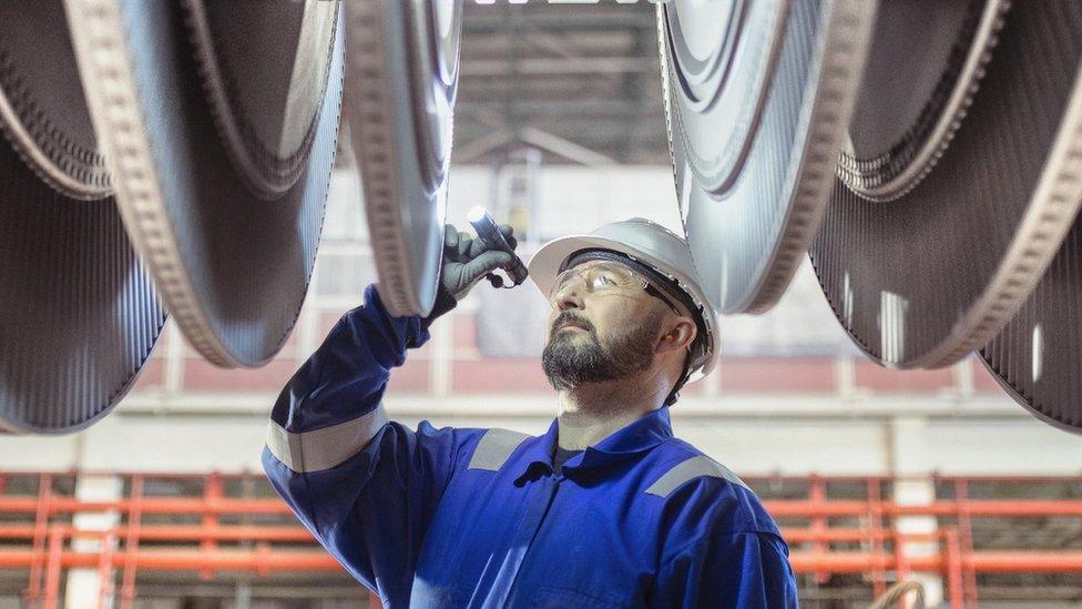 An engineer inspects a turbine in a nuclear power station