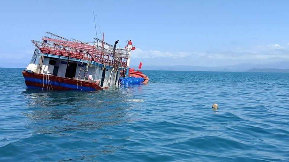 A partially submerged boat that police say was used in a "people smuggling venture"