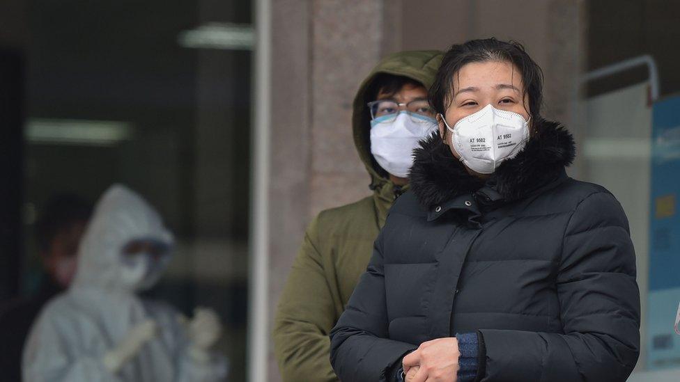 People in protective masks outside Wuhan Fifth Hospital