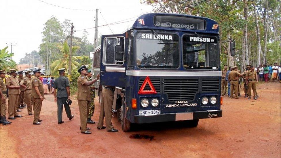 Sri Lankan police officers inspect a prison bus after gunmen opened fire in Colombo, Sri Lanka February 27, 2017.