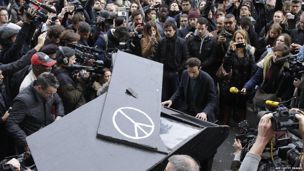 Musician plays piano near Bataclan Theatre