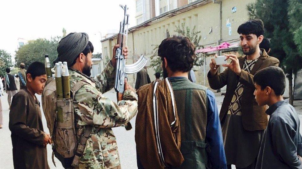 A Taliban fighter poses for a photo at the main square, a day after the insurgents took control of the strategic northern city of Kunduz