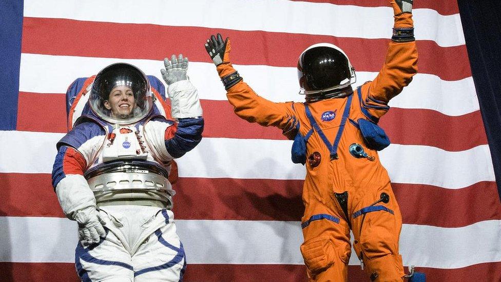 Kristine Davis, a spacesuit engineer at NASA’s Johnson Space Center, wearing a ground prototype of NASA’s new Exploration Extravehicular Mobility Unit (xEMU), and Dustin Gohmert, Orion Crew Survival Systems Project Manager at NASA’s Johnson Space Center, wearing the Orion Crew Survival System suit, right, wave after being introduced by the administrator, Tuesday, Oct. 15, 2019 at NASA Headquarters in Washington