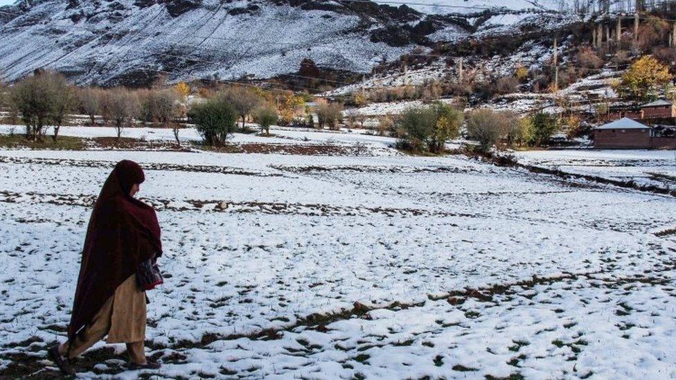 An earthquake victim walks across a snow-covered field in the village of Charun Veer in Chitral valley, Pakistan (November 2015)