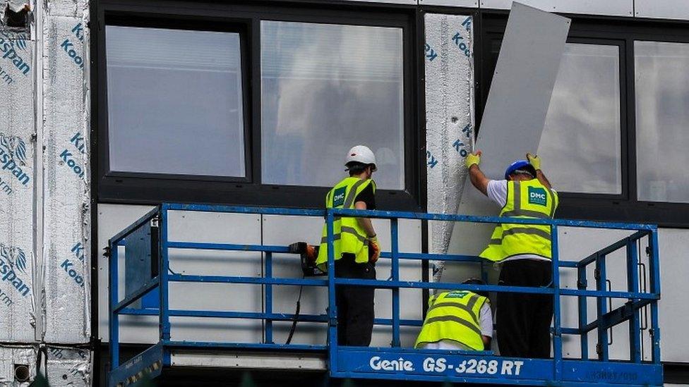 Cladding being removed from building