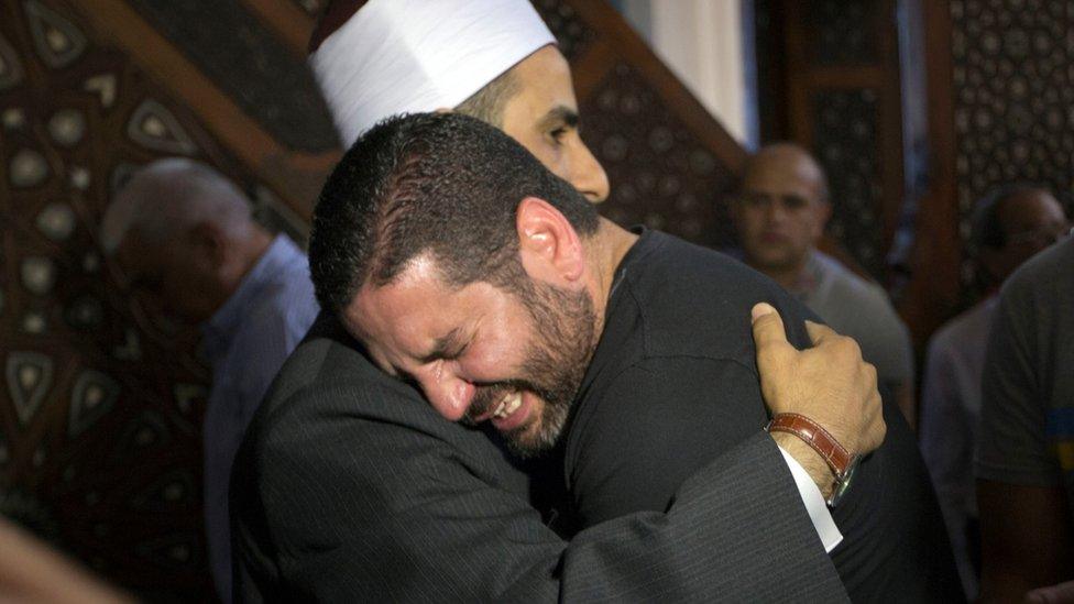 Director Osman Abu Laban, who lost four relatives in a plane crash, is comforted at a mosque