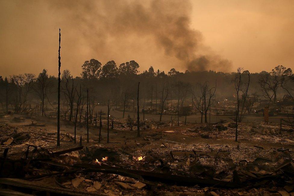 Smoke billows from a neighbourhood that was destroyed by a fast-moving wild fire in Santa Rosa, California, 9 October