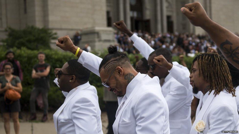 Pallbearers with their fists raised at the funeral of Philando Castile