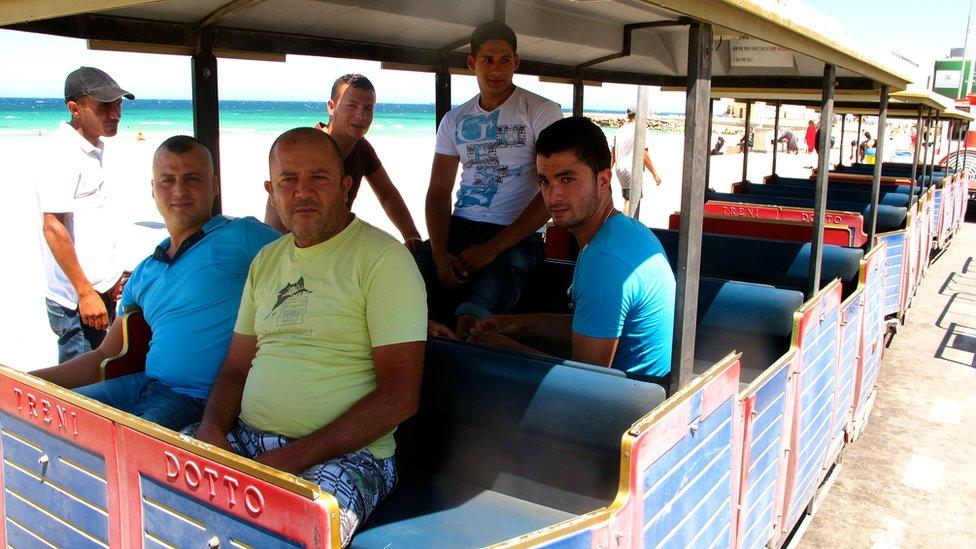 Jeblai Bouraoui (in yellow shirt) and his colleagues seat in their empty tourist train waiting for clients.