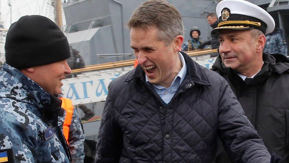 British Defence Minister Gavin Williamson (C) reacts during a meeting with Ukrainian navy sailors in Odessa