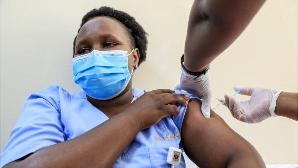 A Kenyan healthcare worker receives vaccinated with an Oxford/AstraZeneca dose