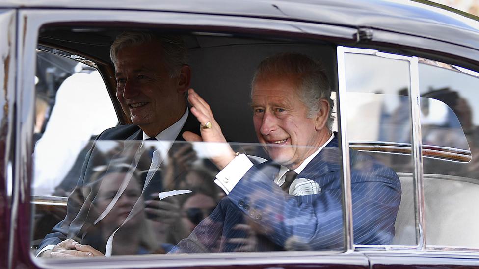 King Charles III waves to well-wishers outside Buckingham Palace