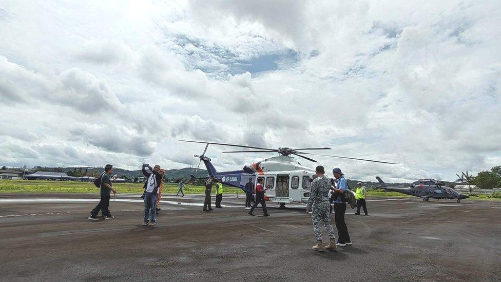 Rescuers and a helicopter prepare to resume search for Mayon volcano plane crash survivors.