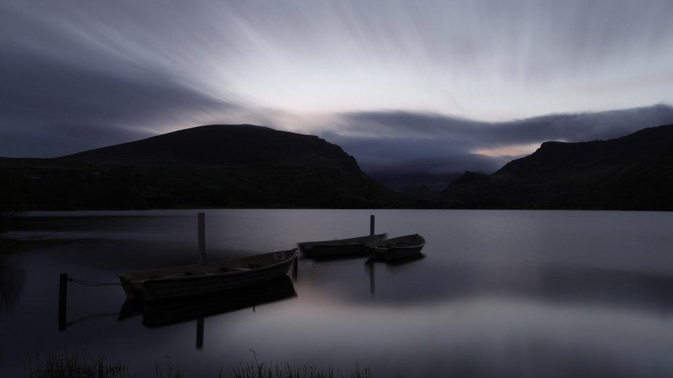 A sunrise over a dark Llyn Nantlle Uchaf