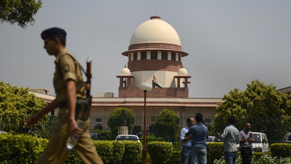 A police officer walks in front of the Supreme Court of India