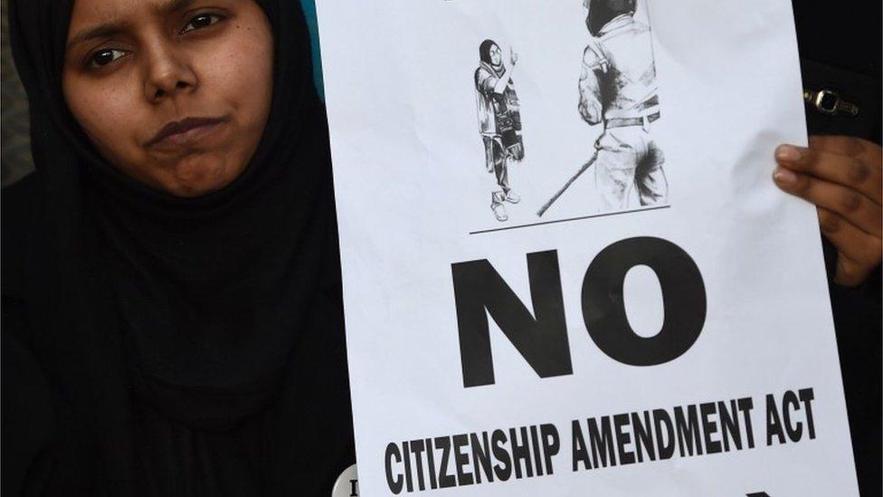 A woman holds a placard at a protest outside Jamia Millia Islamia university in New Delhi