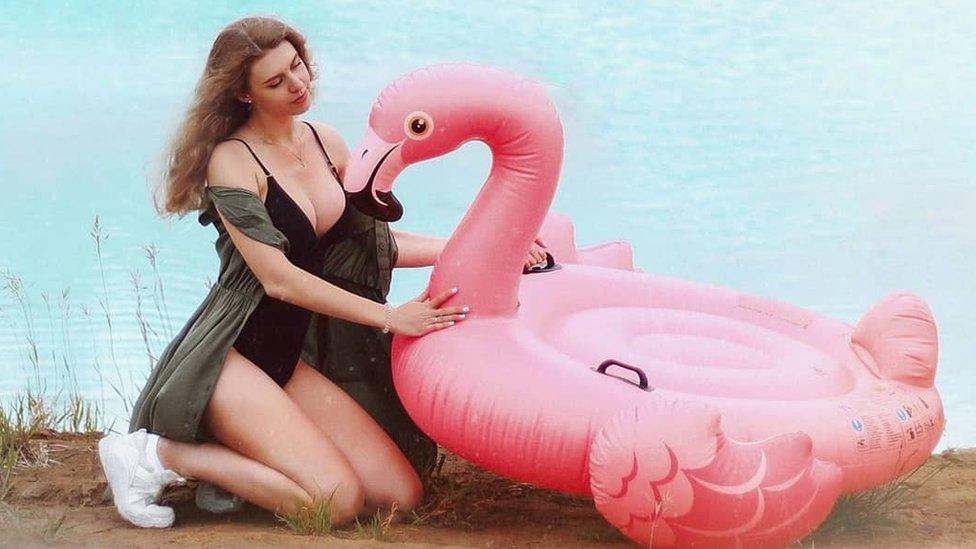 Instagram user poses by the lake with an inflatable flamingo