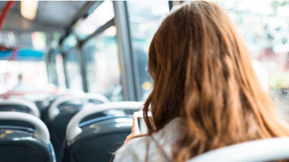 Woman sitting alone in a bus