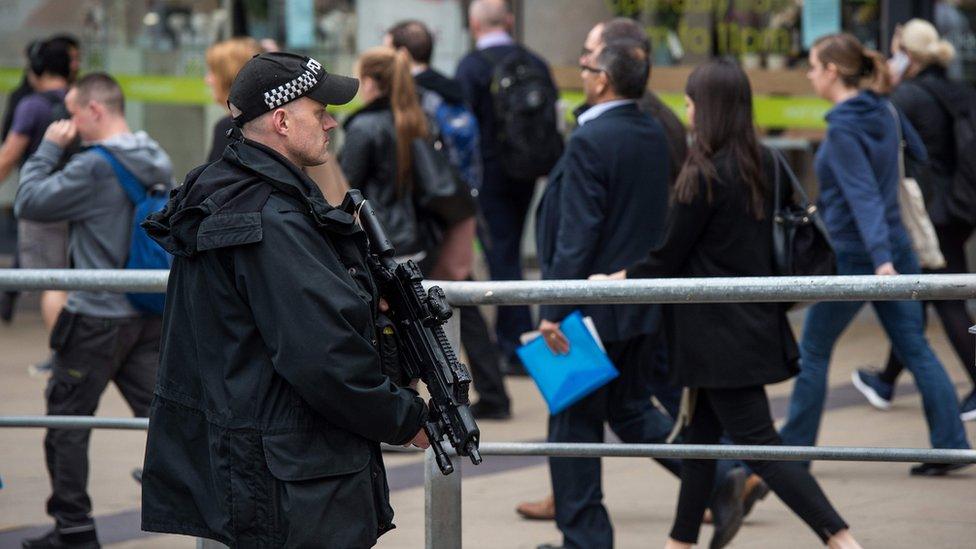 An armed police officer stands on duty outside Manchester Piccadilly train station in Manchester,