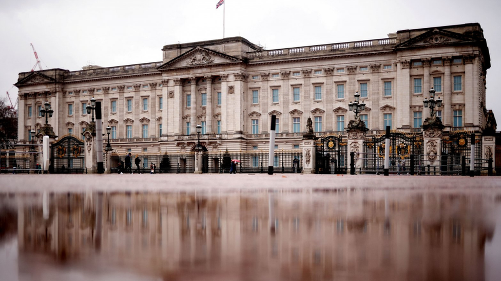 A rain puddle reflects Buckingham Palace in London