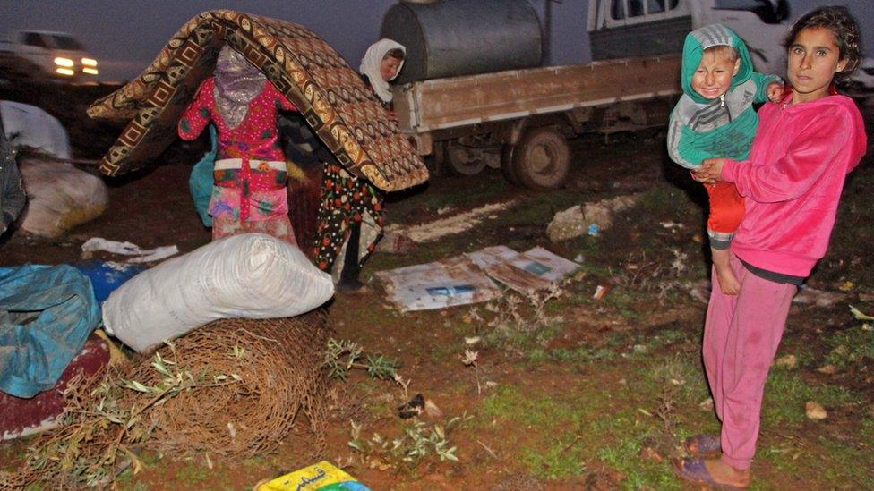 A displaced Syrian family unpacks their belongings at a makeshift camp near the town of Binnish, in Idlib province (5 February 2020)