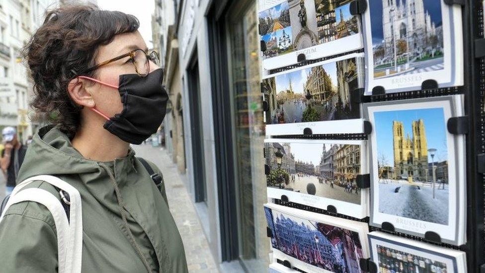 A woman looks at postcards of Brussels in Brussels, Belgium