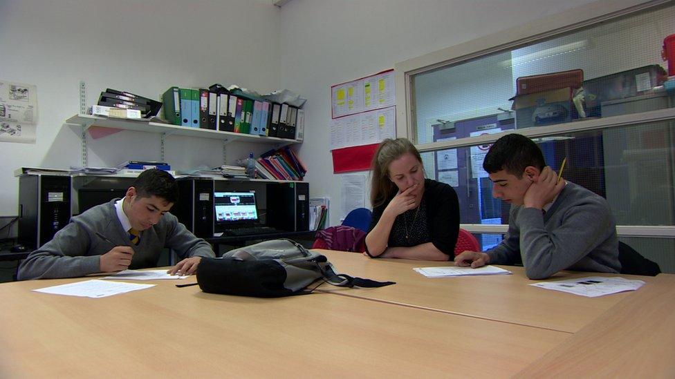 A volunteer teacher helping Omran and his brother with their GSCE studies