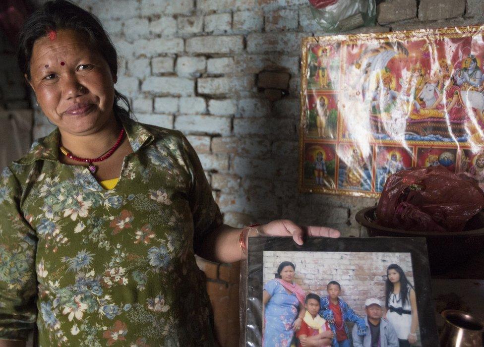 Chandra Kala Magar holds up a family photograph