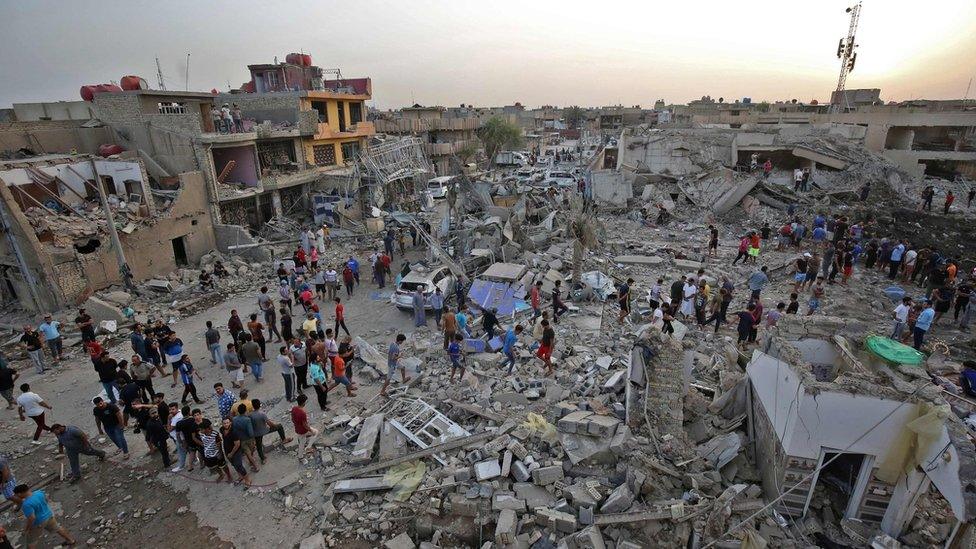 Iraqis inspect the aftermath of explosions that destroyed a mosque in Baghdad's Sadr City district (7 June 2018)