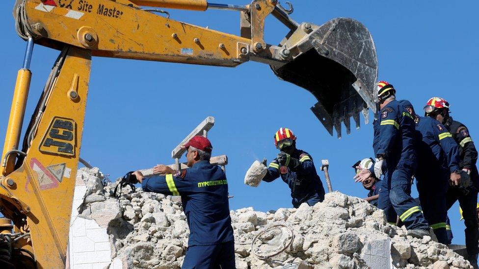 Firefighters look for people in the rubble of a demolished church following an earthquake, in Arkalochori on the island of Crete, Greece, September 27, 2021