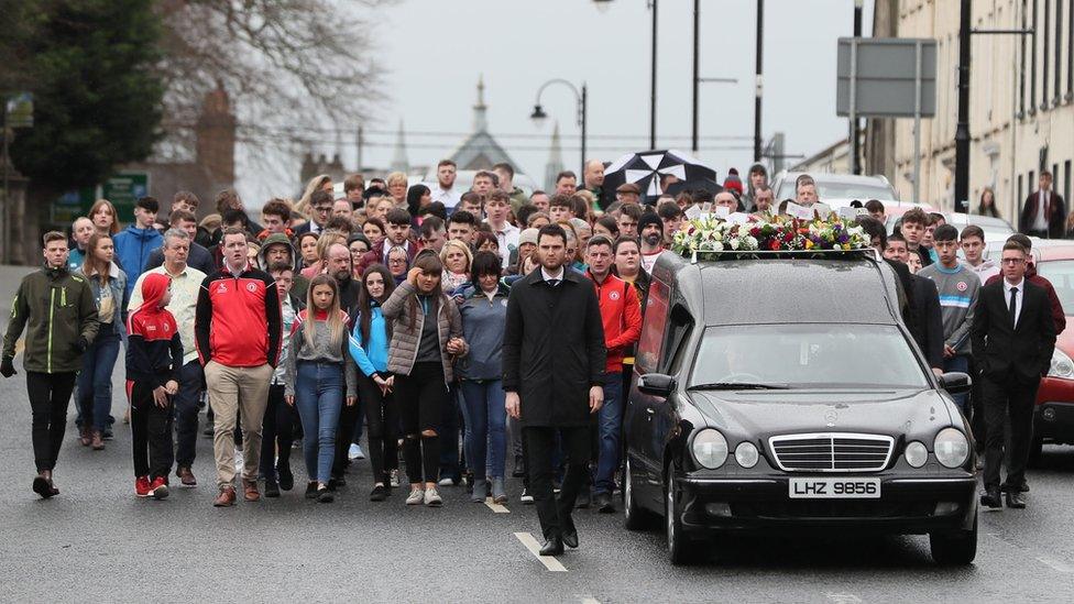 People walking behind the hearse carrying Morgan Barnard's coffin