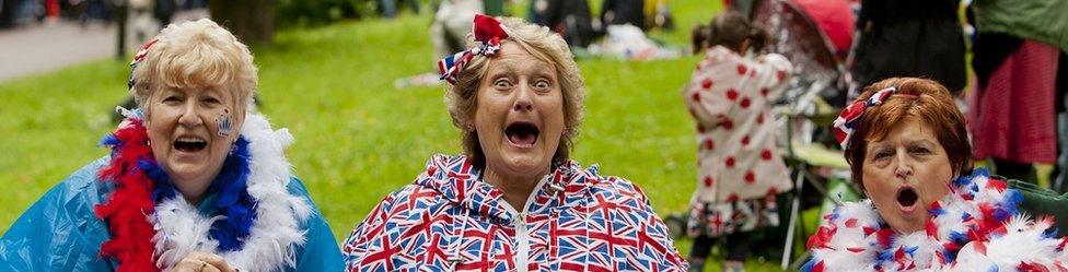 Women dressed in Union flags smile and cheer at the camera