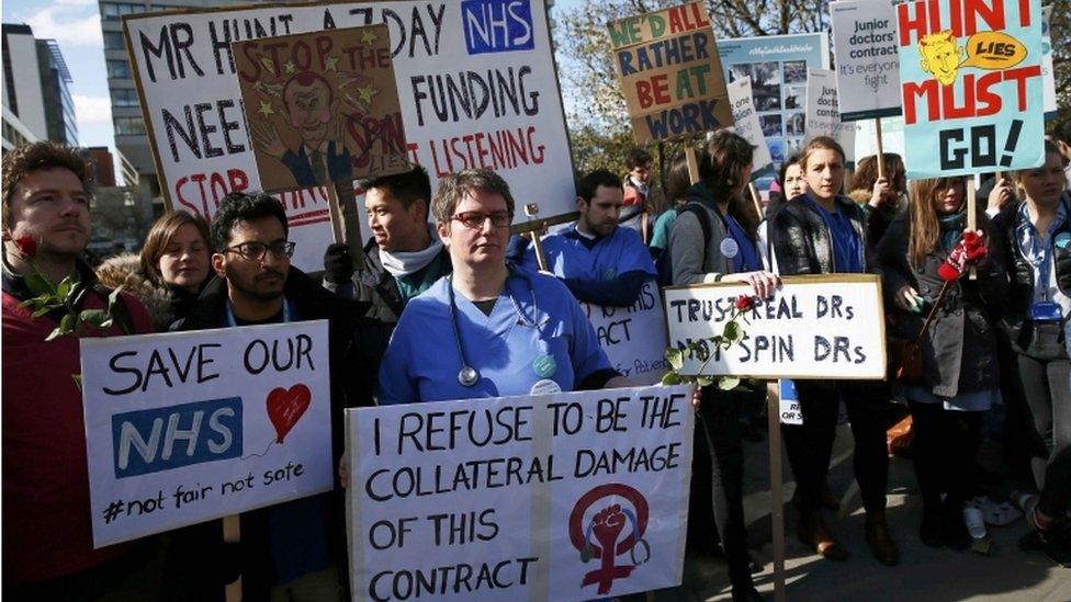 Junior doctors and supporters hold placards during a strike outside St Thomas" Hospital, April 2016