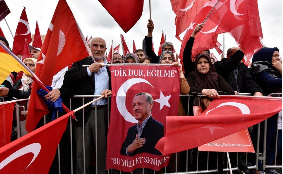 Turkish people protest with a picture of president Erdogan during a demonstration against the Turkey coup attempt in support of Turkey"s president Erdogan in Cologne, Germany, Sunday, July 31, 2016