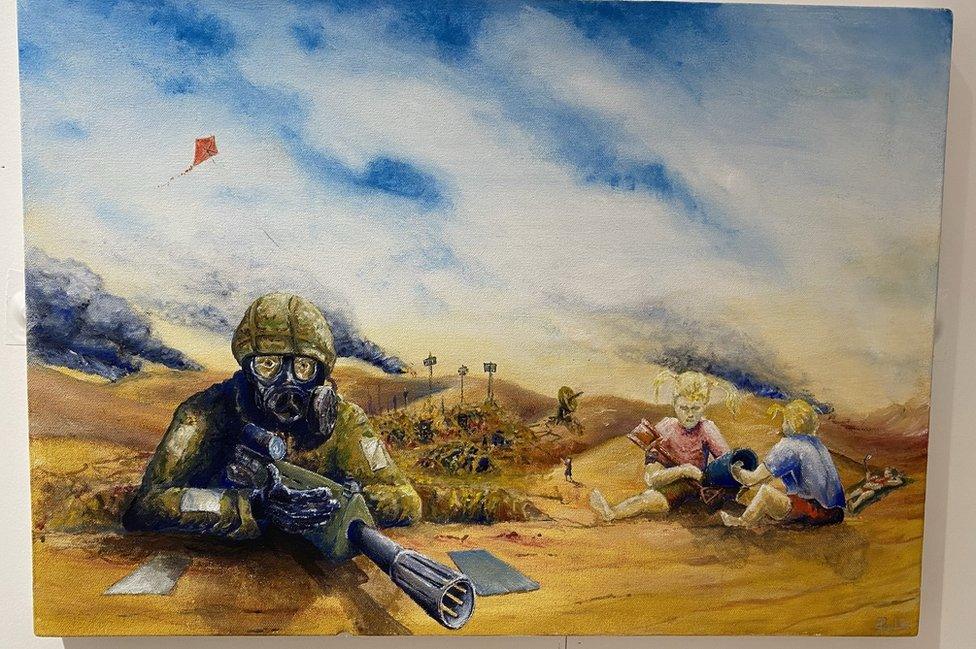 Children playing in sand next to soldier