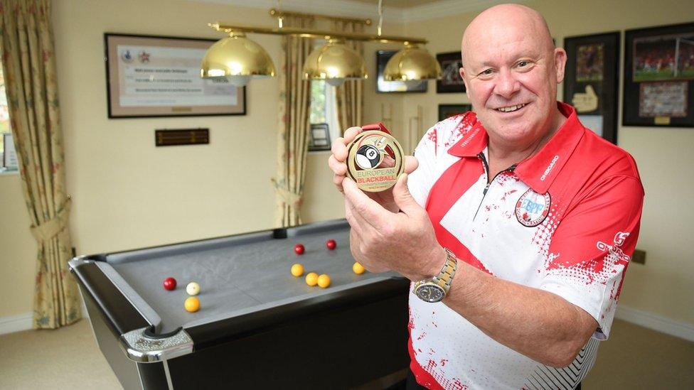 Neil Jones, 59, from Stoke-on-Trent, with his bronze medal he won as part of the England B1 team which he captained at the European Blackball Championships in Malta in November. Mr Jones won £2.4 million on the National Lottery in 2010 and a pool table was one of his first purchases, going on to be selected for England after honing his skills over the Covid lockdown. Issue date: Monday November 20, 2023. PA Photo. See PA story LOTTERY Pool. Photo credit should read: National Lottery/PA Wire