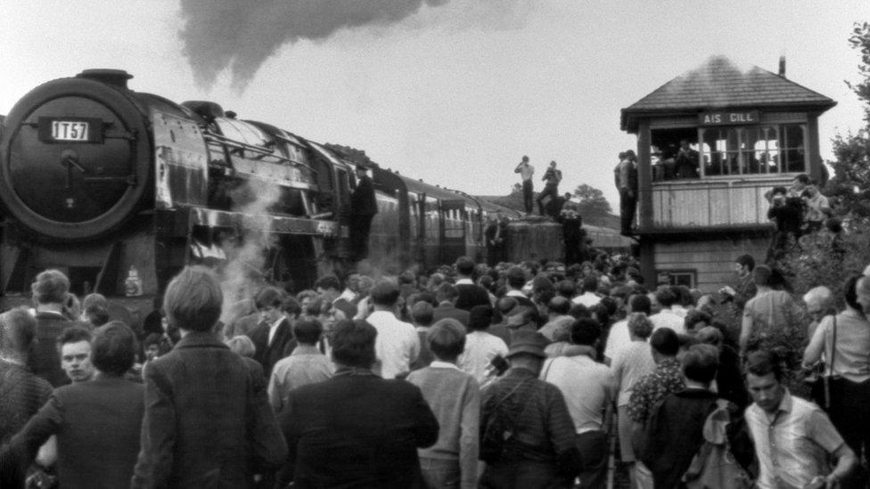 People getting a view of a steam train