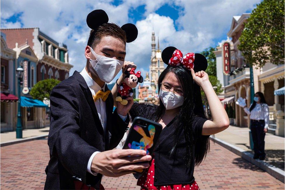 Visitors dressed in costumes take a selfie at Hong Kong's Disneyland