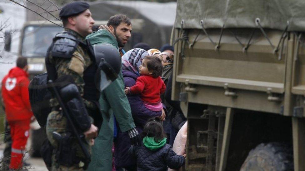 A Macedonian soldier escorts migrants who crossed the border from Greece. Photo: 14 March 2016