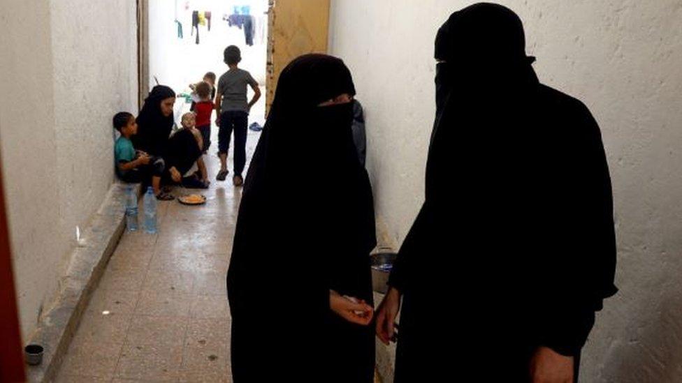 Women whose family members are accused of being Islamic State militants are pictured on July 22, 2017 inside a guarded building at a temporary camp for displaced people near the northern Syrian village of Ain Issa.