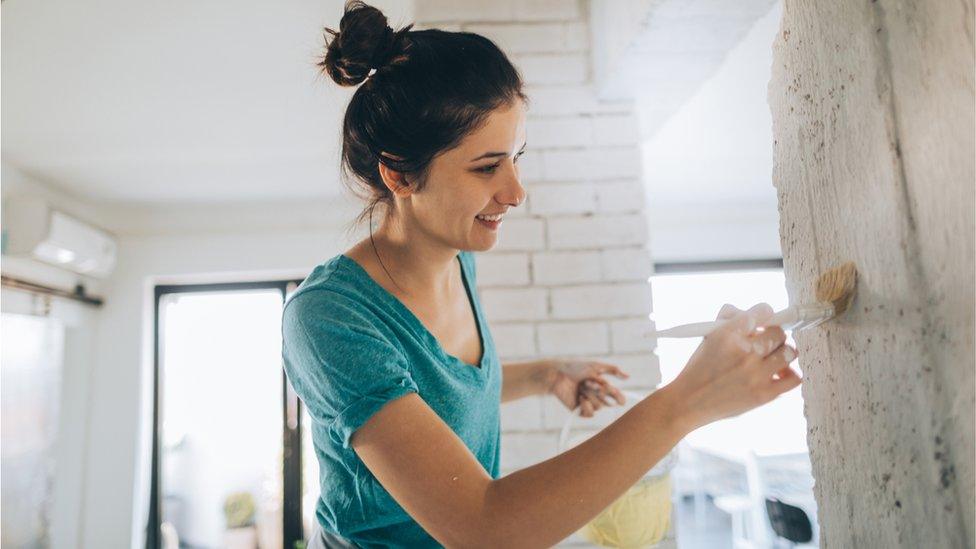 Woman painting a wall