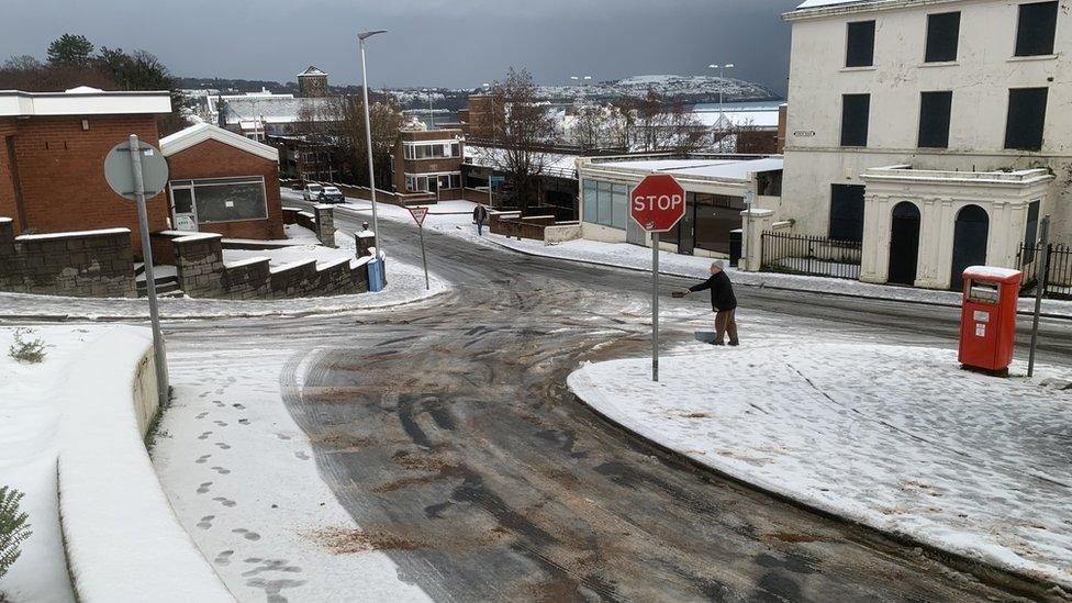 Man spreads grit on icy Isle of Man road