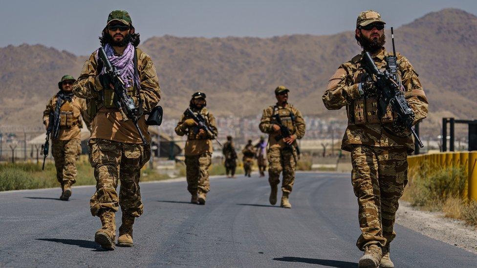 Taliban fighters secure the outer perimeter, alongside the American controlled side of of the Hamid Karzai International Airport in Kabul, Afghanistan