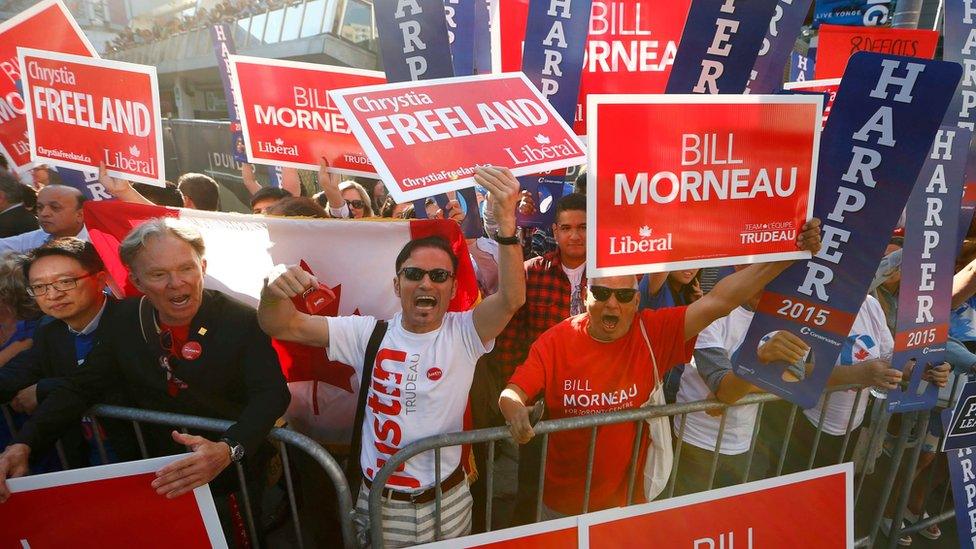 Supporters of Canada's Liberal party wave signs outside the venue for the national leadership debate in Toronto on 6 August