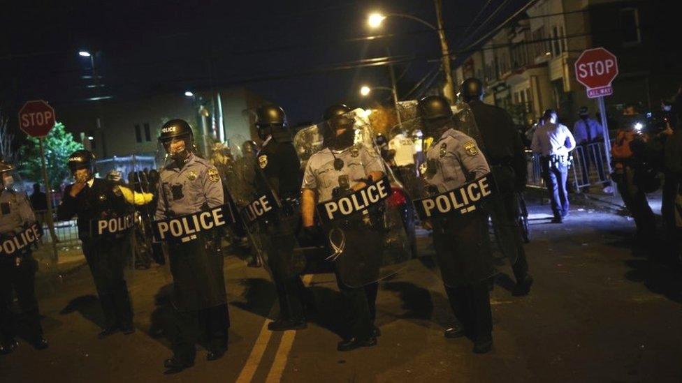 Police officers stand guard outside a police station in Philadelphia