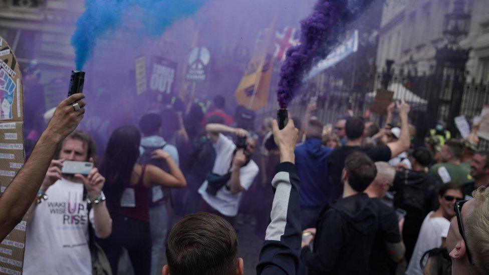 Protesters let off flares outside Downing Street during an anti-lockdown protest in central London.