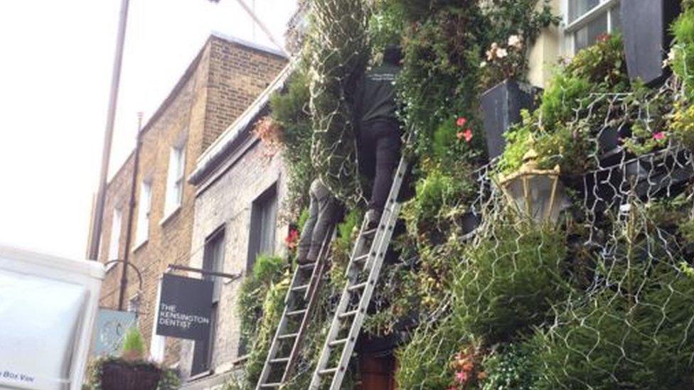 Christmas decorations being put up outside The Churchill Arms pub