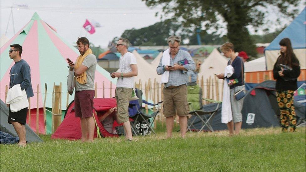 Ed Balls (3rd right) and his wife Yvette Cooper (2nd right) waiting in a queue for the showers during the Glastonbury Festival at Worthy Farm in Pilton, Somerset