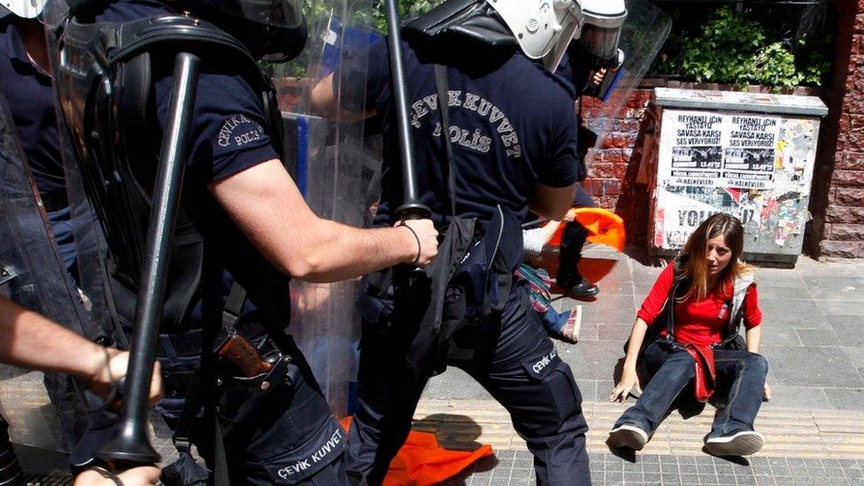 Riot police surround a demonstrator during a protest against Prime Minister Recep Tayyip Erdogan and his government's policy on Syria, in Ankara on 18 May 2013