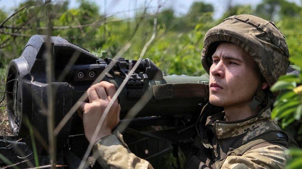 A Ukrainian service member holds a next generation light anti-tank weapon (NLAW)